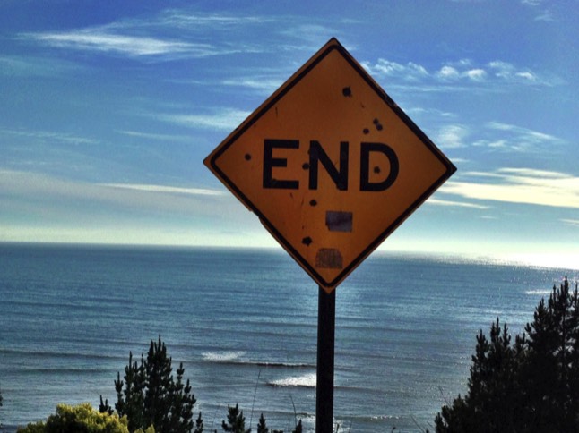 sign that says end in front of ocean and sky